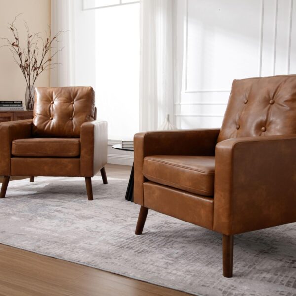 Two caramel-colored leather chairs with tufted backs in a cozy living room setting, ideal for reading or relaxation.